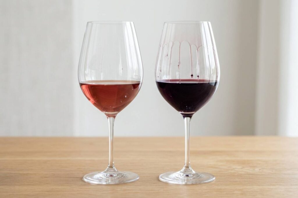 Comparativo da lágrima do vinho entre duas taças - uma de rosé e outra de tinto